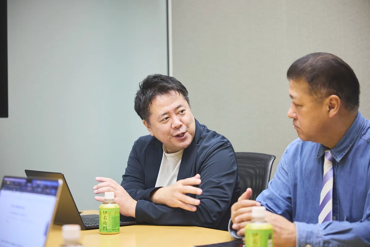 向かい合って会話する中谷部長と石井課長代理